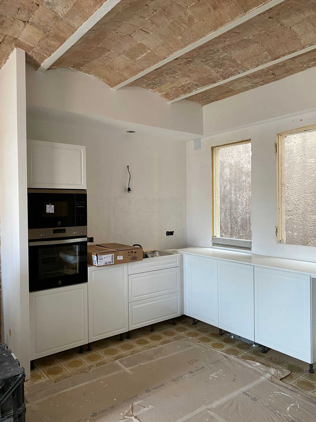Cocina en reforma con bóveda catalana y muebles blancos
