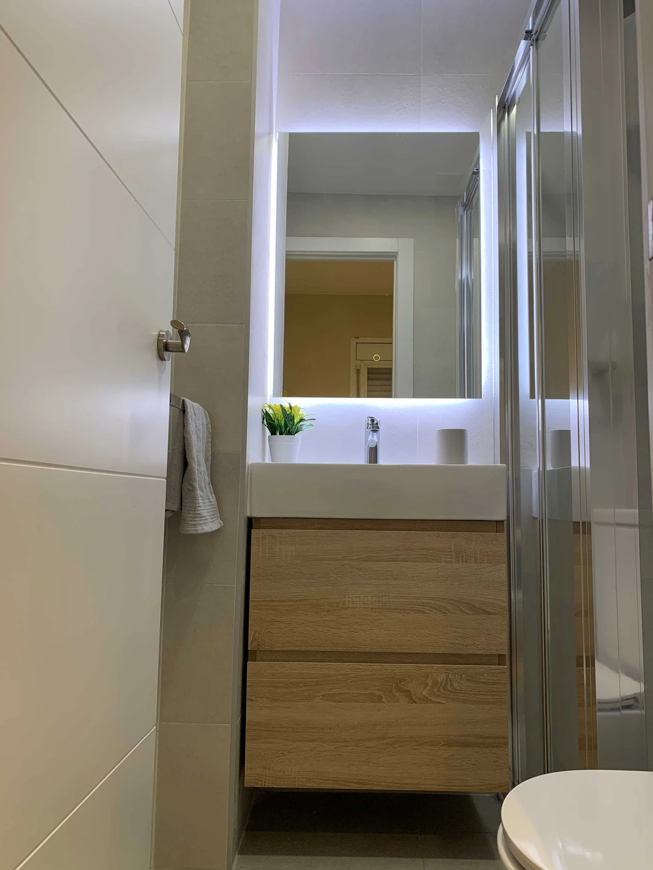 Baño pequeño con mueble suspendido y espejo iluminado