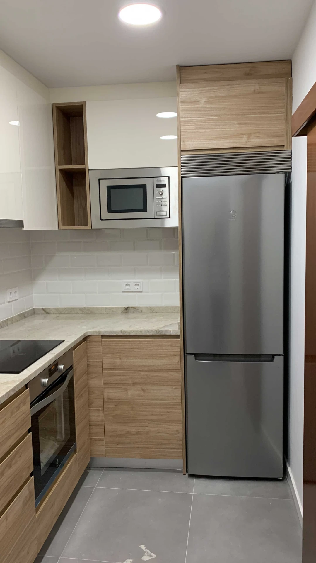 Cocina con muebles de madera, nevera y horno integrados