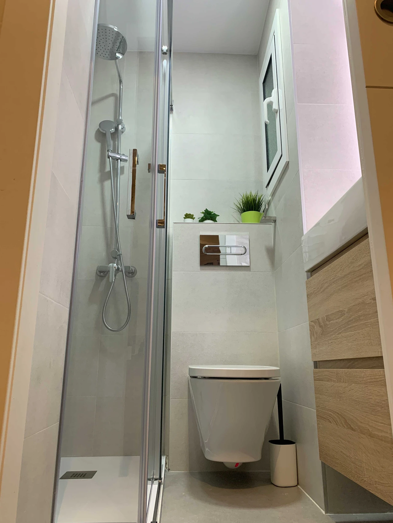 Ducha empotrada con inodoro suspendido en baño reformado
