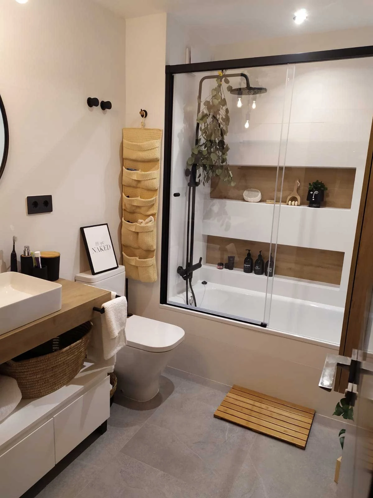 Baño con bañera, nichos de obra y acabados en madera