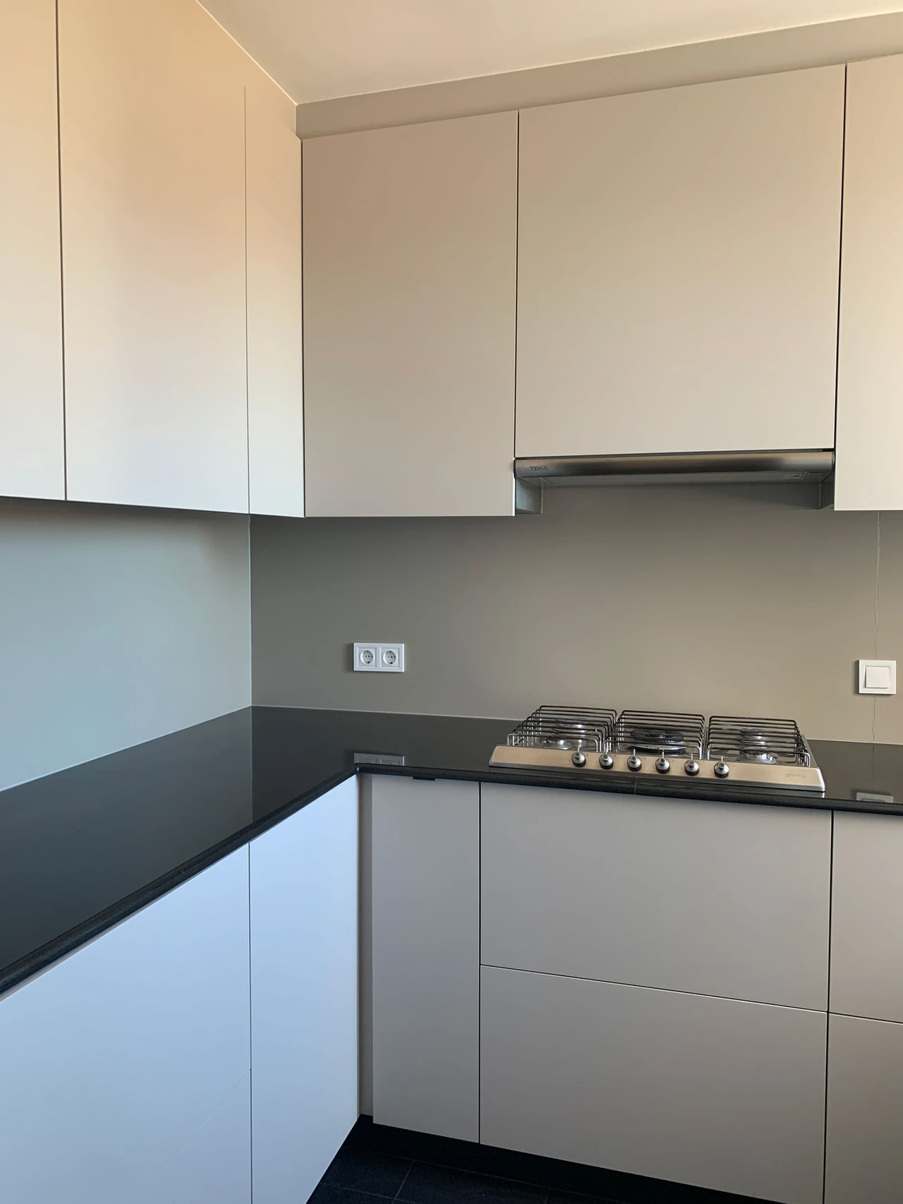 Cocina terminada con muebles blancos y encimera negra